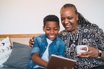 Grandmother and grandchild taking selfie with tablet.