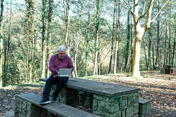 Fototapeta premium Mature man working with a laptop in the field