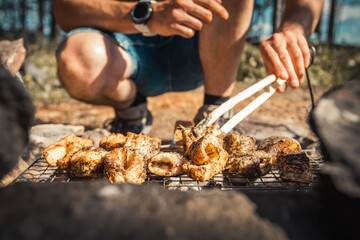 Cooking fish steaks over open fire while camping in nature. BBQ weekend, grilled trout