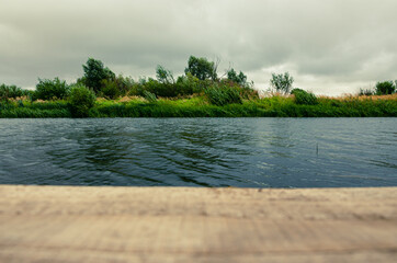 Cloudy summer scene with waves on water surface during windy rainy morning