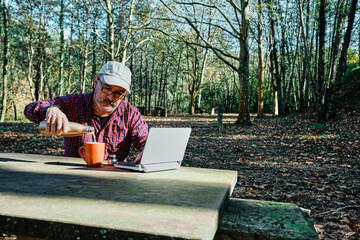 Fototapeta premium Mature man working with a laptop in the field