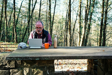 Fototapeta premium Mature man working with a laptop in the field