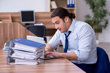 Obraz premium Young male employee unhappy with excessive work