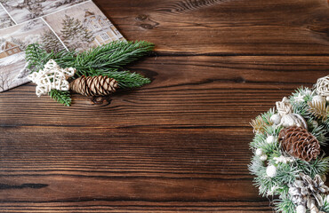 Christmas wreath, fir eyelids, pine cones and a card on a wooden background close-up.