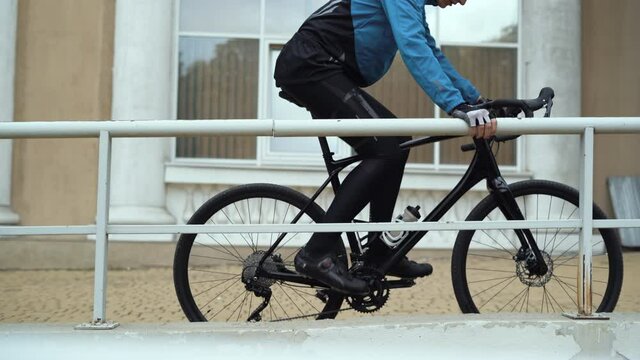 male cyclist drives up to the railing locks his vehicle