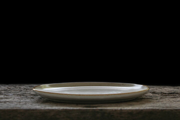 Empty white ceramics plate and on wooden background.