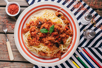 Pasta bolognese eggplant on the table, restaurant dish on a wooden background