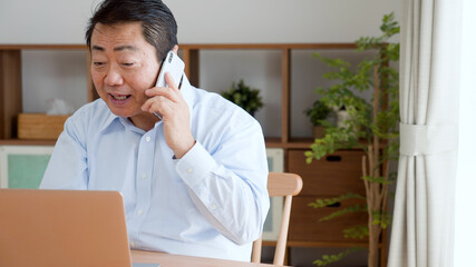 仕事の電話をする中年男性