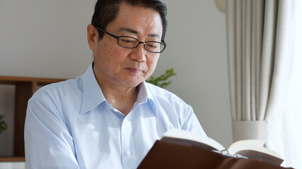 本を読んでいる中年男性