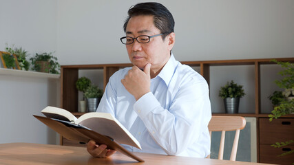 本を読んでいる中年男性