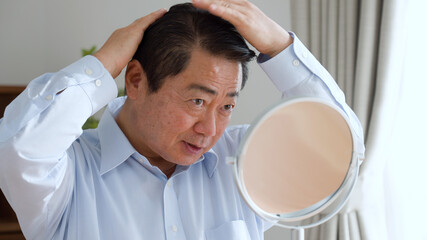 髪の毛を整える中年男性