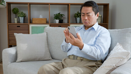 携帯電話を使う中年男性
