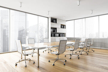 White office meeting room with wooden table and armchairs near window