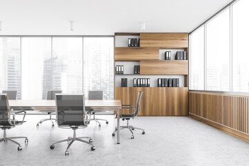 Office meeting room with table and chairs, wooden bookshelf near window