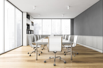 White office meeting room with wooden table and armchairs near window