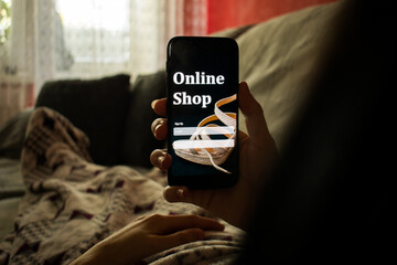 Woman lying in bed with a smartphone, shopping online concept.