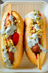Hot dog with carrots to go. Disposable tableware with vegetarian fast food close-up