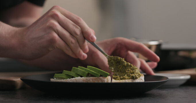 man makes sandwich with pesto and mozzarella