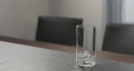 Slow motion pour cola into highball glass with crushed ice on concrete countertop with copy space