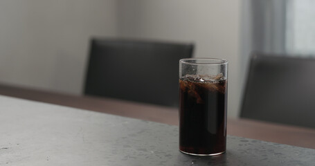 cola in highball glass with crushed ice on concrete countertop with copy space
