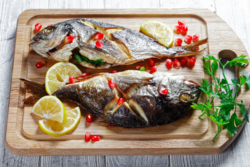 Whole baked dorado fish on a cutting board