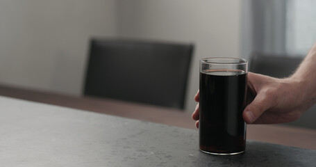 Slow motion man hand take cola in highball glass with crushed ice from concrete countertop with copy space