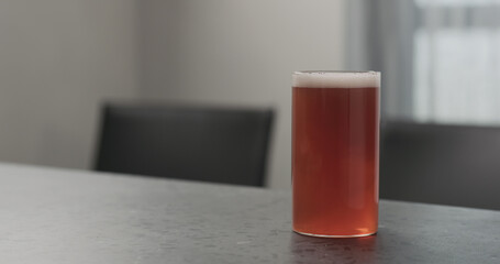 orange soft drink in highball glass on concrete countertop with copy space