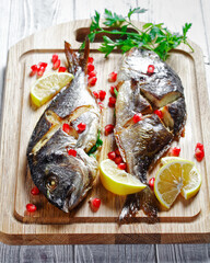 Whole baked dorado fish on a cutting board