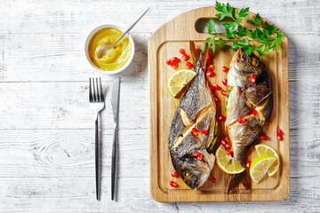 Whole baked dorado fish on a cutting board