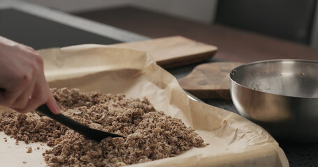 Slow motion making granola, spread on baking sheet