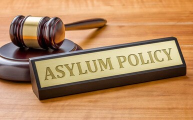 A gavel and a name plate with the engraving Asylum Policy