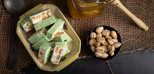 Homemade pistachio nougat on a dark rustic background top view.