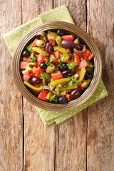 Tomato and green pepper salad Chlada felfel recipe close-up in a bowl on the table. vertical top view from above