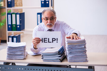 Old male employee unhappy with excessive work in the office