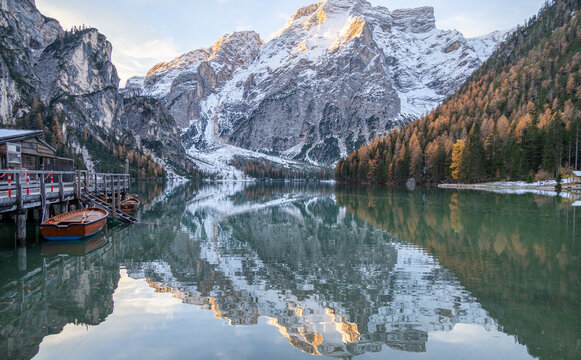 The beautiful, scenic view of Braies Lake, in the Dolomite mountains, in the Trentino Alto Adige region. Mountains reflecting in the still water, wooden house and a docked boat. Postcard magic © laura