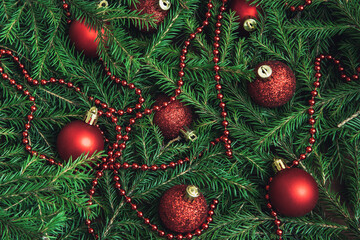 Background texture of Christmas tree branches with red baubles and beads