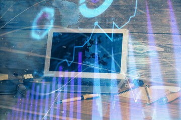 Financial graph colorful drawing and table with computer on background. Double exposure. Concept of international markets.