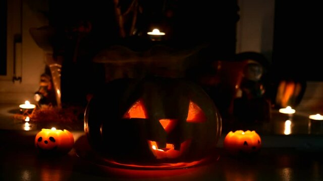 Home decoration with spooky glows halloween pumpkin head Jack Lantern face and burning candle. Carved eyes, mouth. Traditional Halloween symbol. Close-up.