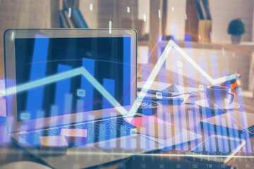 Financial chart drawing and table with computer on background. Double exposure. Concept of...