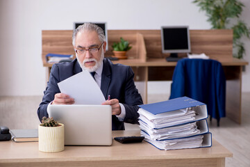 Old male employee working in the office