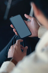Closeup image of man hand using smartphone while sitting in office, blank screen for your graphic design.