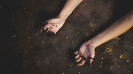 hands of artist stained with paint on black background. flat lay for painter