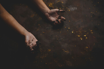 hands of artist stained with paint on black background. flat lay for painter