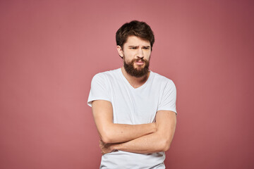 Man in white t-shirt emotions lifestyle facial expression cropped view pink background.