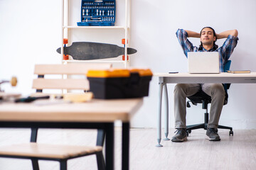 Young man repairing skateboard at workshop