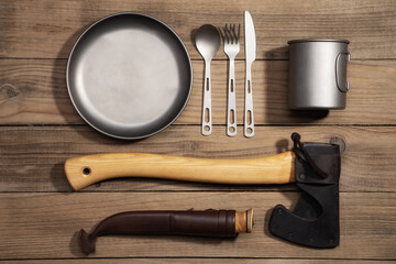 Flat lay composition with different camping equipment on wooden table. Travel equipment for a...