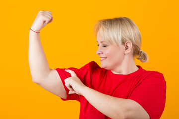 beautiful young plump female in a red t-shirt on a yellow background