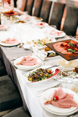 Festive table setting with snacks and flowers in the restaurant. Wedding table decor for guests