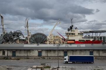 SHIP IN SEAPORT - Specialized watercraft moored at the wharf against the background of old...