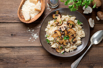 Risotto with brown champignon mushrooms on wooden background. top view